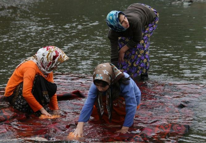 Des femmes iraniennes lavent un tapis tissé à la main dans un lac Des femmes iraniennes lavent un tapis tissé à la main dans un lac